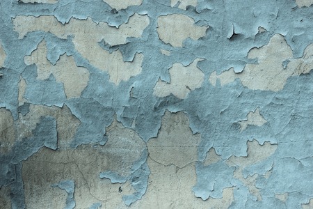 Gray textured concrete wall with blue peeling paints. Dirty painted stone background, city building wallpaper with place for textの写真素材
