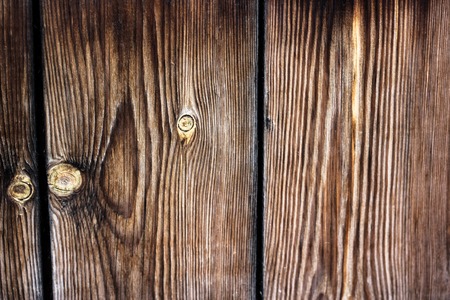 Brown textured old wooden boards background. Abstract closeup shot of bright lined wood country...