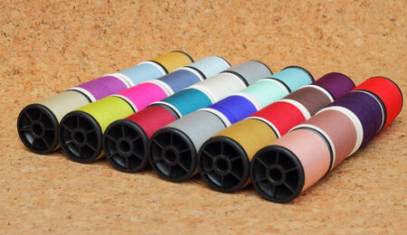 Spools of thread  multicolored on cork boardの写真素材