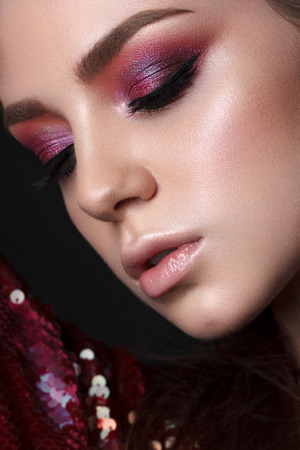 Close up portrait of beautiful young model with professional makeup, perfect skin. Trendy colorful smoky eyes. Red and lilac smoky eyesの写真素材