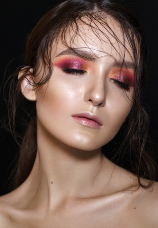 Portrait of beautiful young model with professional makeup, perfect skin, wet hairdo. Trendy colorful smoky eyes.の写真素材