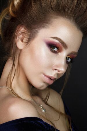 Close up portrait of beautiful young woman with professional makeup, perfect skin, volume hairdo. Trendy colorful smoky eyes.の写真素材