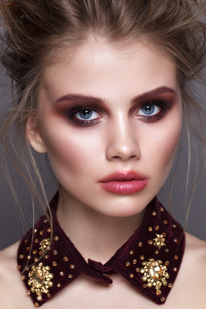 Close up portrait of beautiful young model with unusual makeup, perfect skin, volume hairstyle. Trendy smoky eyes and kissed lips.の写真素材
