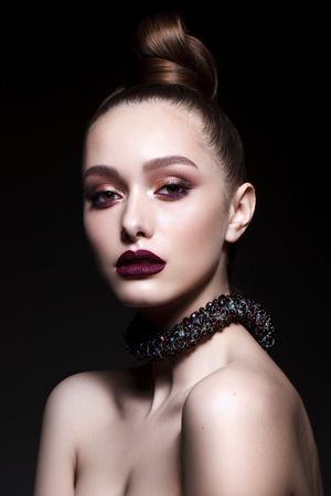 Beautiful young model with fashion make up, perfect skin, stylish hairdo. Trendy lip colorの写真素材