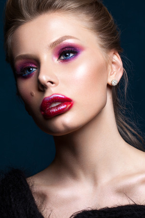 Portrait of blond model with professional makeup, perfect skin, creative lips art. Trendy colorful smoky eyes. Red and lilac smoky eyesの写真素材