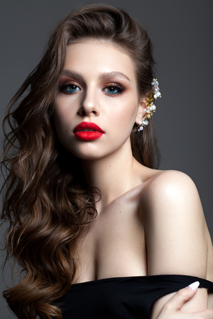 Beautiful young model with professional makeup, perfect skin, red lipsの写真素材