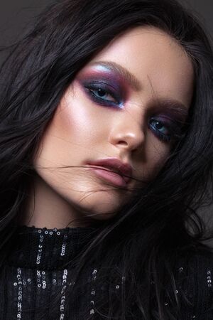 Beautiful sexy girl with professional evening makeup, perfect shining skin. Trendy colorful smoky eyes.の写真素材