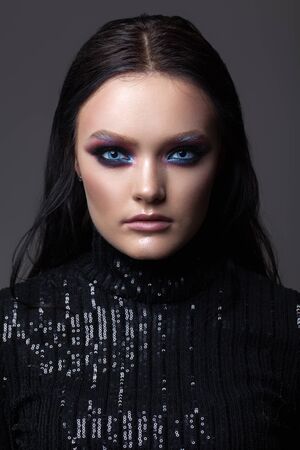 Beautiful sexy girl with professional evening makeup, perfect shining skin, blue eyes. Trendy colorful smoky eyes.の写真素材