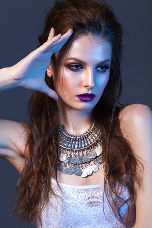 Attractive young model with professional make up, silver necklace, volume hairdo.の写真素材