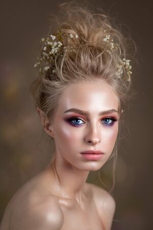 Attractive blond model with a volume curl hairstyle, colorful smoky eyes and perfect skinの写真素材