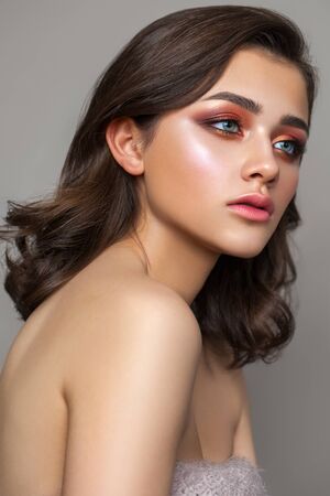 Beautiful young brunett girl with colorful trendy smoky eyes, bright blue eyes and wavy hair.の写真素材