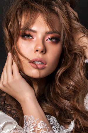 Young model with professional makeup, perfect skin, long wavy brown hair. Nude lookの写真素材