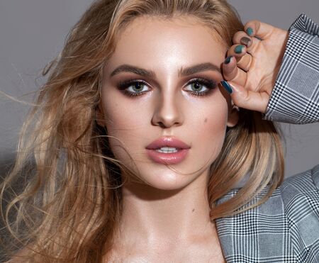 Portrait of young beautiful blond model with a day professional make up, rich eyebrows and lashes.の写真素材