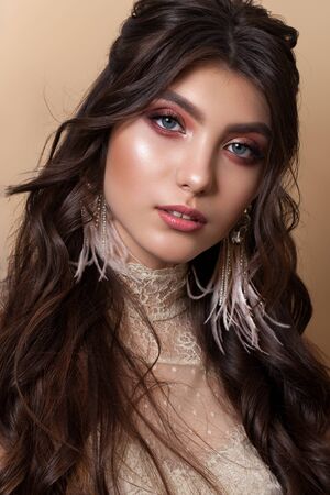 Fashion portrait of a very beautiful brunette model with professional rose gold makeup, perfect skin and wavy hairstyle.の写真素材