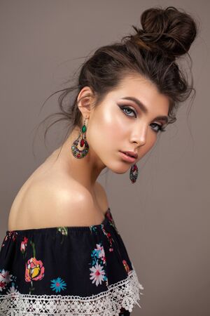 Fashion portrait of a beautiful brunette girl with blue eyes, professional makeup, perfect skin and ethnical accessoriesの写真素材
