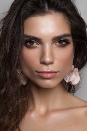 Photo of a beautiful brunette girl with hazel eyes and square jaw and chin. Perfect skin, light professional make up.の写真素材