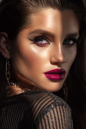 Beautiful sexy fashion model with bright professional makeup, wavy hair, perfect skin, red vine lips and a lot of trendy necklacesの写真素材
