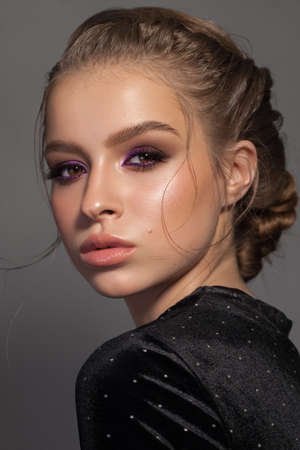 Beautiful young model with evening professional makeup, hairstyle, perfect skin, in black dressの写真素材