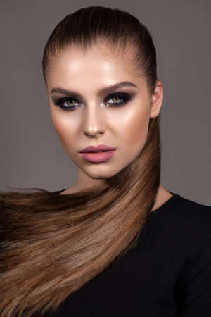 Fashion young model with professional smoky eyes make up, perfect skin, long hairの写真素材