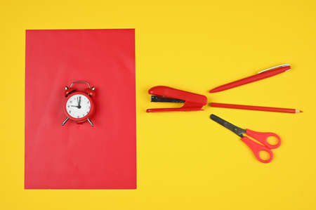 Alarm clock and stationery in red and yellow tones. High quality photoの写真素材