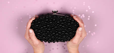 Womens fashion. Black handbag on violet background. Flat composition. magazines, social media. Top...