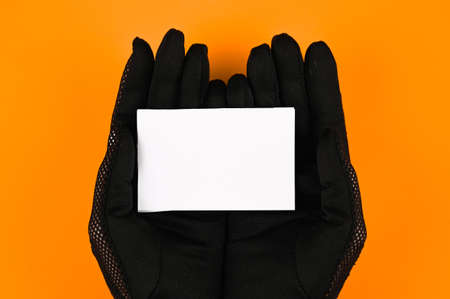 Close-up of female hands in black gloves with blank card. Template for design mockup. Black friday and sales conceptの写真素材