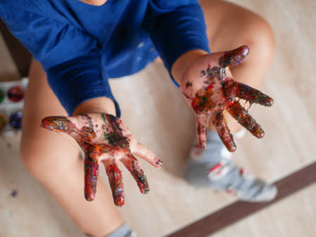 The childs hands are stained with colored paint.の写真素材