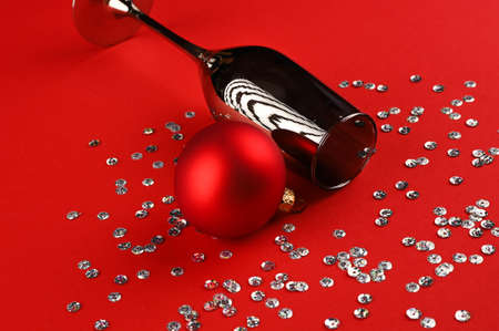 Christmas composition with champagne glass, christmas ball and scattered sparkles.の写真素材