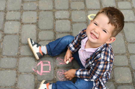 Portrait of smiling toddler boy on the background of chalk drawings.の写真素材