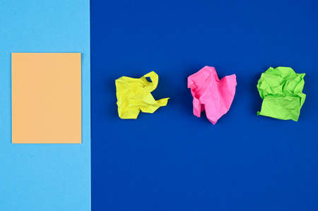 Sticky note and crumpled paper on blue background.の写真素材