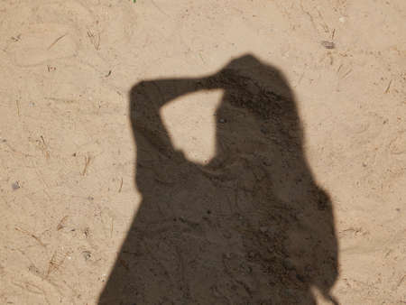 Female shadow on the sand on a sunny day.の写真素材