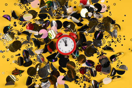 Festive backdrop with multicolored sparkles and alarm clock. Social media postcard.の写真素材