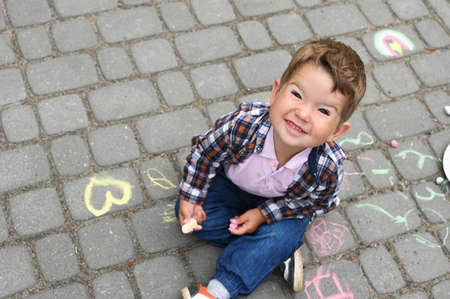 Portrait of smiling toddler boy on the background of chalk drawings.の写真素材