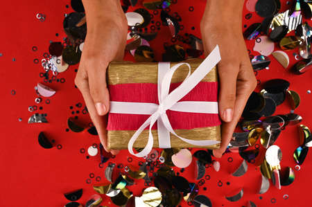 Hands holding gift in package with with ribbon and kravt paper.の写真素材