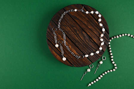 Top view of jewelry with pearls and chains on a vintage wooden stand. Fashion blog concept. Copy spaceの写真素材