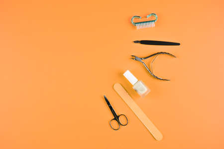Top view of manicure tools on a orange background with copy space. Trendy beauty devices. Beauty and body care concept.の写真素材