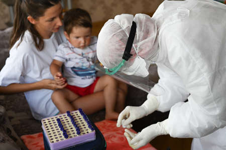 The doctor takes the blood from a little boy. World pandemic concept.