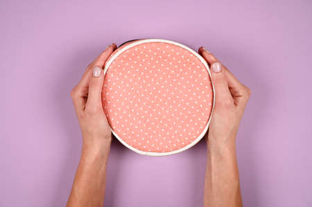 Woman holding stylish round handbag on violet background with copy space. Tender hands with pastel fingernails. Beauty and fashion conceptの写真素材