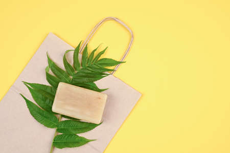 Homemade soap bar, crafted package and green branch.の写真素材