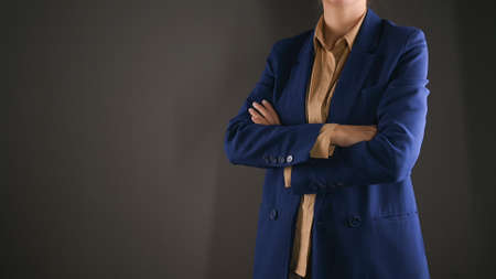 Business woman in a suit crossed her arms over her chest isolated on gray background. Finance and business conceptの写真素材