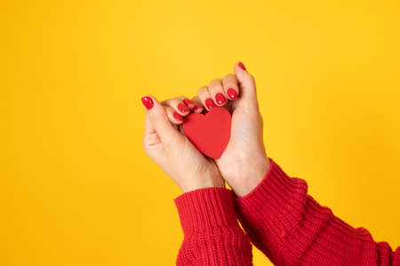 Valentine's day background. Female hands holding red hearth. Minimal composition for 14 February celebration.  High quality photoの写真素材