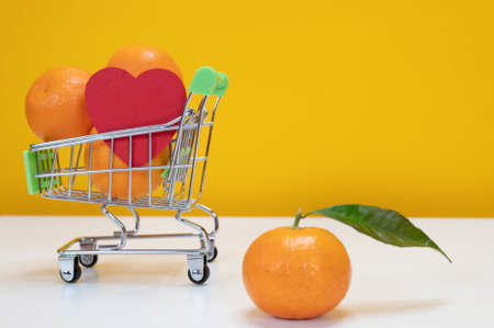 Fresh clementines in supermarket shopping chart. Heart symbol. Healthy life style and nutrition concept. Plenty space for text. High quality photoの写真素材