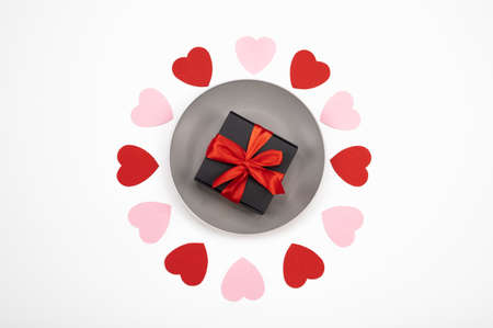 Postcard with gift box on plate and paper hearts frame isolated on white. Greeting gift card. Valentine's Day postcard. High quality photoの写真素材