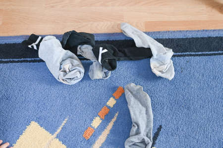 Scattered dirty men's socks on the floor, hygiene concept. High quality photo