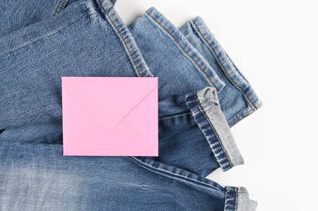 Blank pink envelope on blue jeans background with copyspace for sale text or business isolated on...