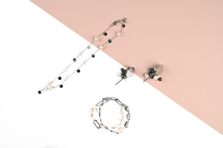 Trendy choker, braselet and earrings with pearls on a white and pink. Fashion Jewelry. Top view. High quality photoの写真素材