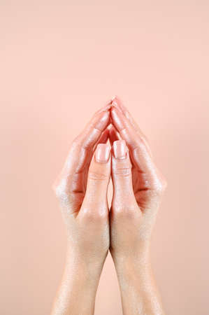 Women's palms folded together. Partial view of tender female hands painted in silver. ... High quality photoの写真素材