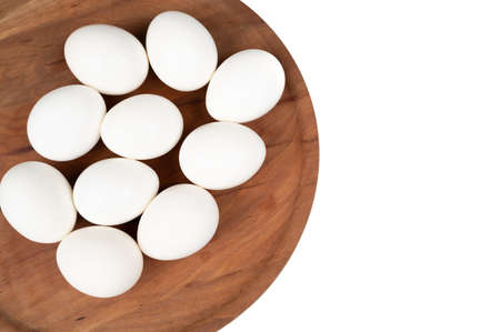 White eggs on a wooden plate isolated on a white background. Organic eggs. ... High quality photo