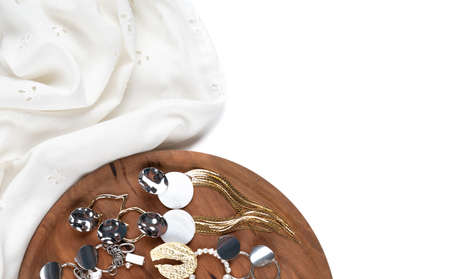 Trendy stylish bijouterie set on white cloth and wooden display. Jewelry with pearl isolated on white. High quality photoの写真素材