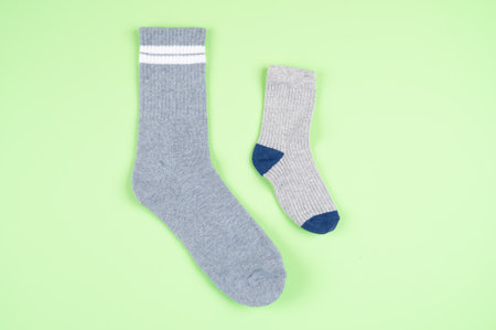 Adult and children's socks on a pistachio-colored background. High quality photoの写真素材